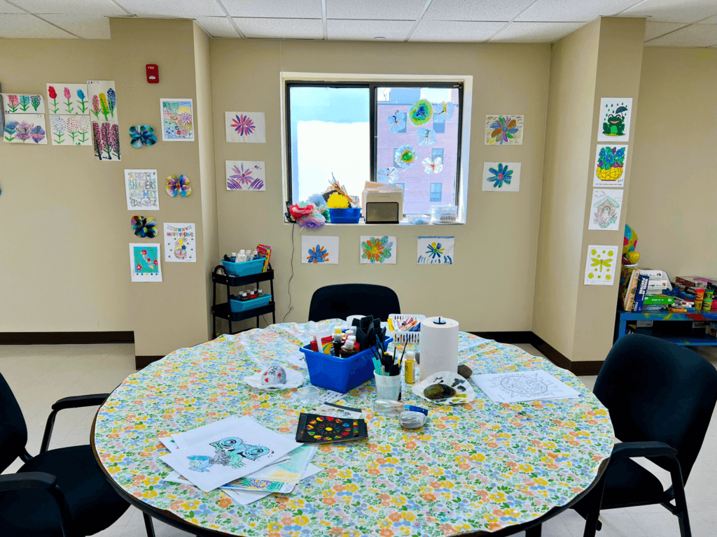 Arts and Crafts Area Arts and crafts table with participants’ artwork displayed on the walls at Penn Village adult day care in Germantown, Philadelphia