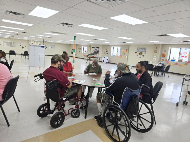 Members playing games together at tables, including members using wheelchairs